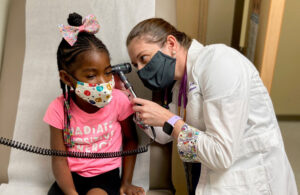 Nurse practicioner examines child during wellness visit